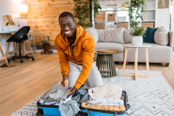istock Young man unpacking his suitcase at home 2186488112