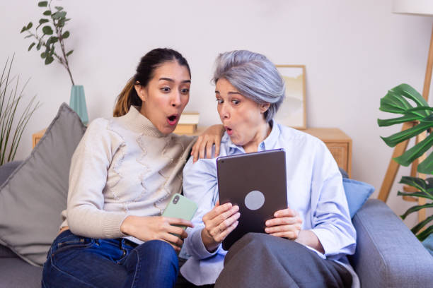istock Mother and daughter sharing a moment of surprise while using a tablet at home 2186490018