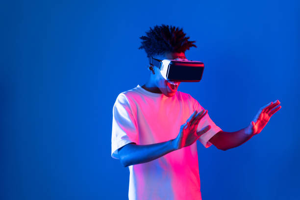 istock Young African player wearing VR point hologram 3D neon light wall. Contrivance. 2186492488