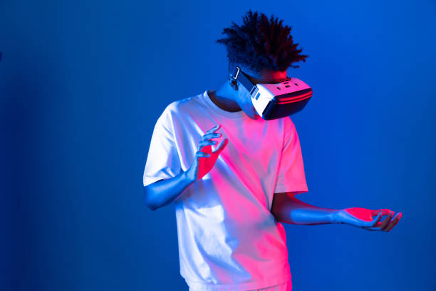 istock Surprised African looking VR holding object hologram neon wall. Contrivance. 2186494046