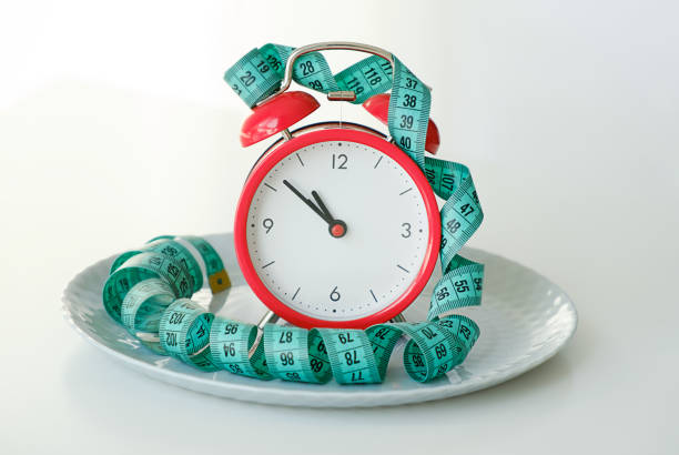 istock A red clock on the plate and tape measure, Intermittent fasting diet concept 2186494109