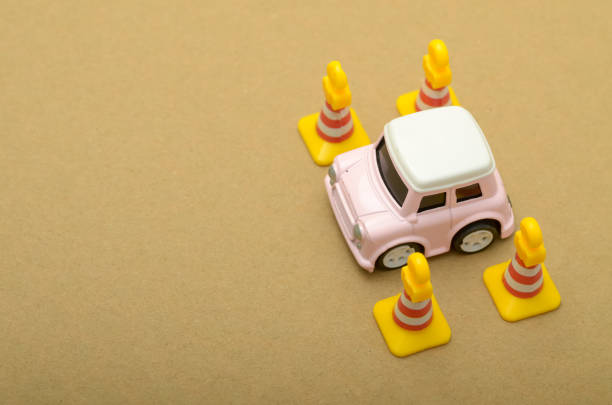 The toy car represents a beginner driver, practicing their skills in a controlled environment before taking to the road.