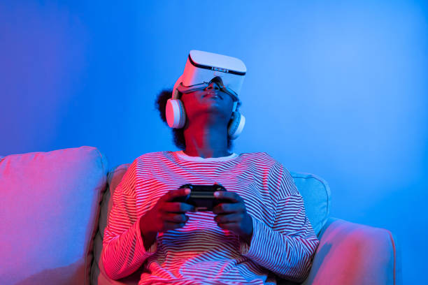 istock Smiling African playing gaming player wearing VR control joystick. Contrivance. 2186495665