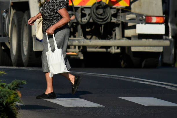 Woman with shopping at a pedestrian crossing.