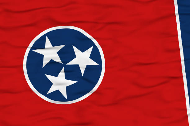 The Tennessee state flag features three white stars within a blue circle, symbolizing the three grand divisions of the state. The vibrant red background and dynamic folds create a sense of motion as the flag waves in the wind.