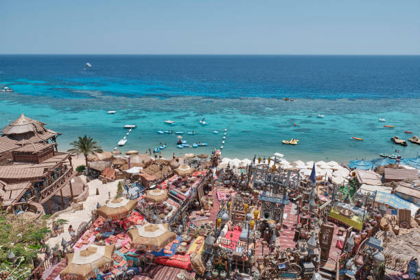 Sharm El Sheikh, Egypt - April 30, 2024: Colorful beachfront cafe Farsha with traditional decor, handicraft items, overlooking turquoise sea.Umbrellas, rustic seating,charm to vibrant coastal scene