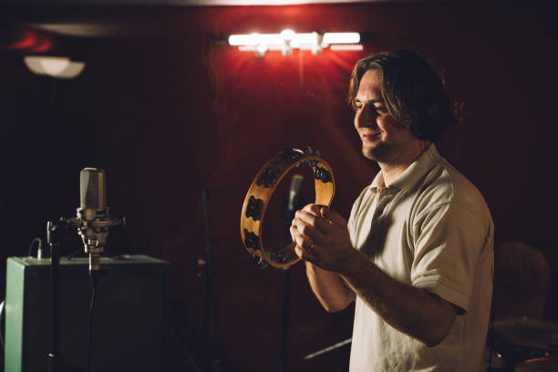 Musician playing a tambourine during a recording session