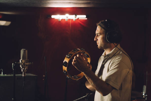 istock Percussionist recording tambourine sounds in a professional studio 2186509216