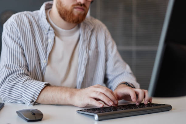 istock Man Typing at Desk in Office Environment 2186518818