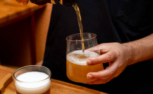 istock man pouring beer from bottle into glass 2186523325
