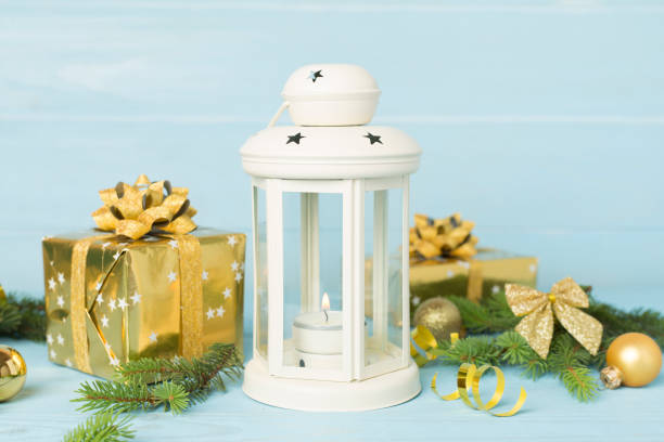Beige christmas lantern with decorations on wooden table