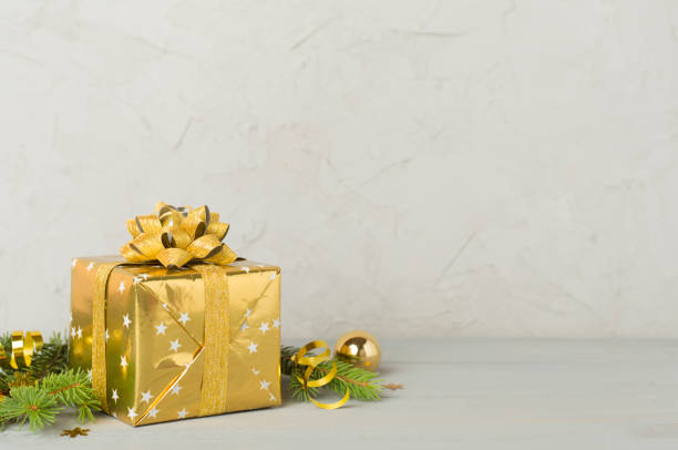 istock Golden gift box with christmas decor on concrete background 2186528152