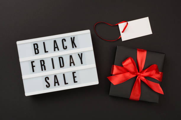 istock Light box with Black friday sale text and gift box on color background, top view 2186529534