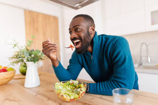 istock Happy man enjoying a fresh salad bowl in a modern kitchen 2186531831