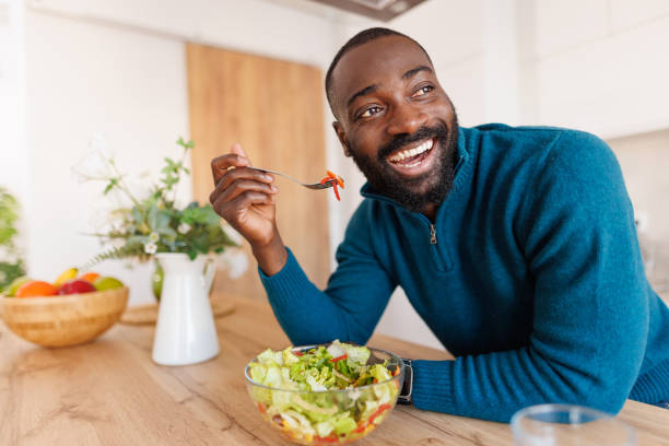 istock Man with salad enjoys vibrant meal in bright kitchen scene 2186531841