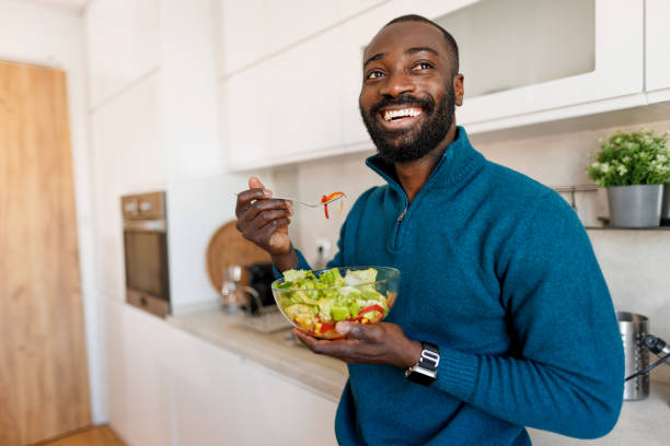 istock Smiling man stands in the kitchen savoring a home salad bowl 2186531857