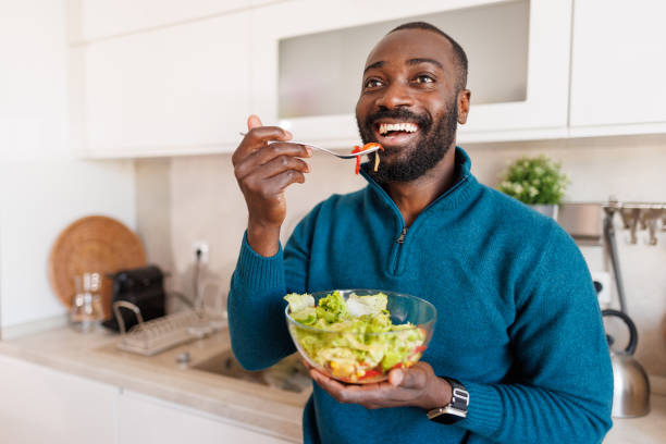 istock Man enjoying healthy salad in modern kitchen with a smile. 2186531859