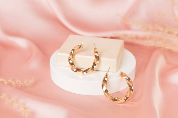 istock Golden earrings with decor on color background 2186531924