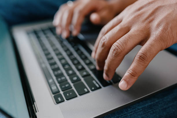 istock Closeup of hands typing on laptop on lap 2186535277