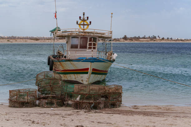 istock fishing boats moored right next to the sandy beach 2186539323