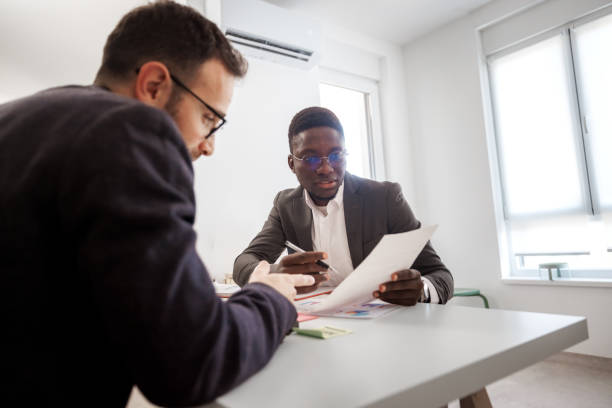 istock Two businessmen talking while working together at the modern office 2186541205