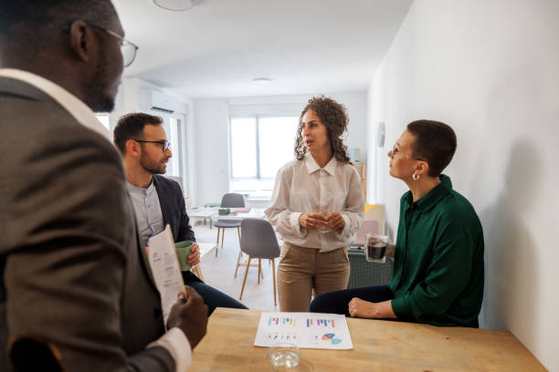 istock Group of colleagues talking about work during coffee break at the small office kitchen 2186541313