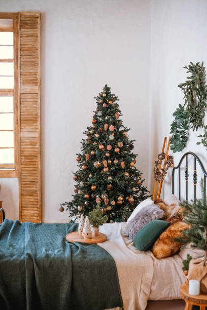 istock Cozy bedroom decorated for the holidays with a Christmas tree and warm textures 2186543578