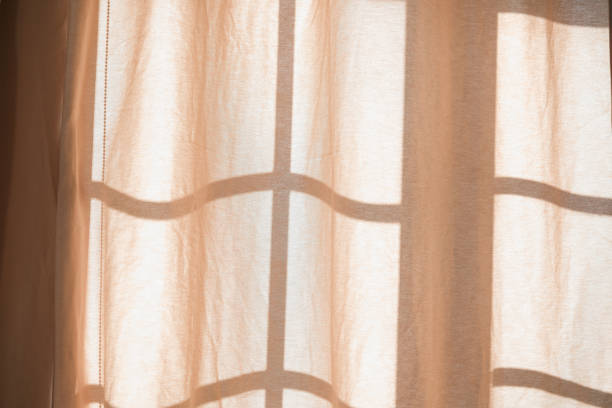 istock Soft sunlight filtering through sheer curtains in a cozy room 2186543613