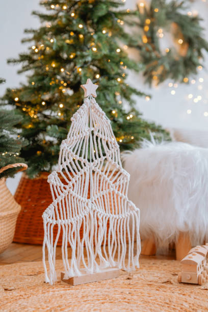 istock Decorative macrame Christmas tree with festive lights and greenery in cozy room 2186543881