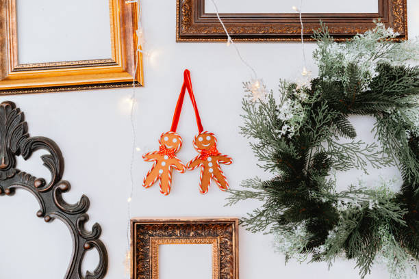 Gingerbread decorations hang among picture frames and a festive wreath