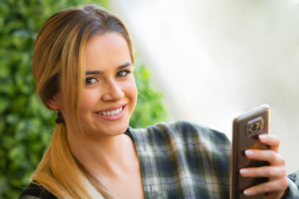 istock Young Blonde Entrepreneur Smiling While Checking Finance on Android Phone in Modern Coffee Shop 2186556913