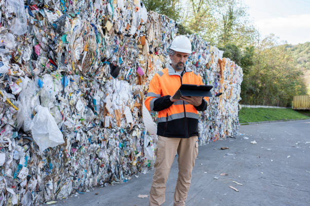 istock Worker Inspects Compacted Waste Bales in Recycling Factory 2186566098