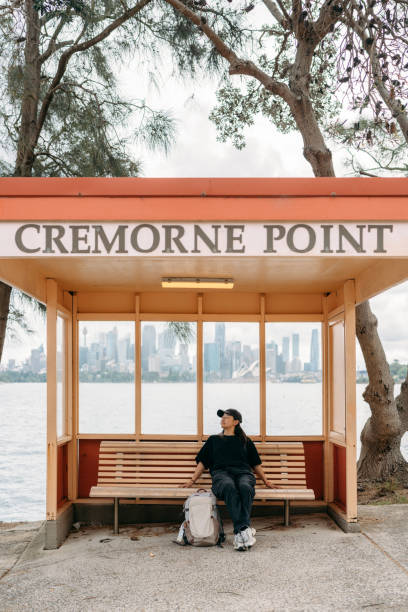 Under the shelter at Cremorne Point, a woman sits calmly, enjoying the quiet surroundings and distant city views