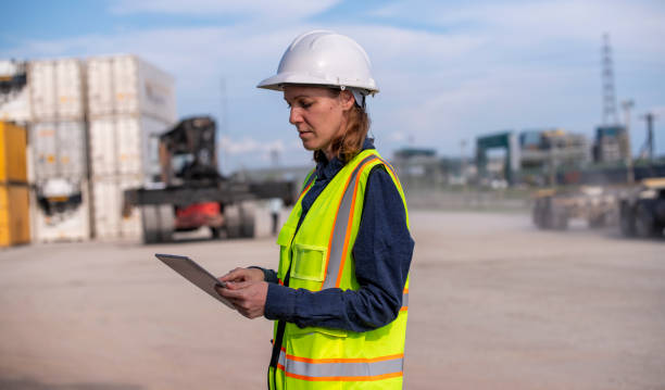istock Engineer or worker team are standing forklift or truck vehicle are working appear discussing or reviewing document, likely related inspect container factory and industry transportation import export. 2186571669