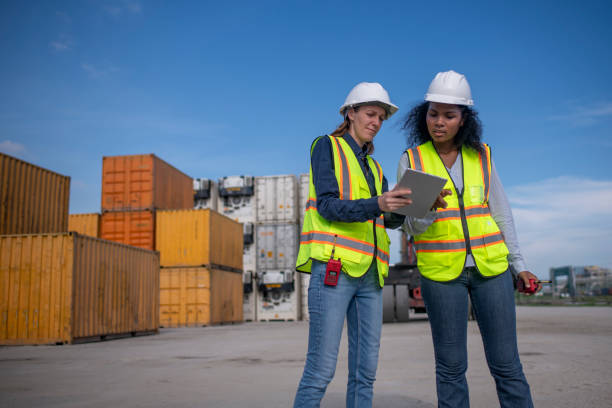 istock Engineer or worker team are standing forklift or truck vehicle are working appear discussing or reviewing document, likely related inspect container factory and industry transportation import export. 2186571678