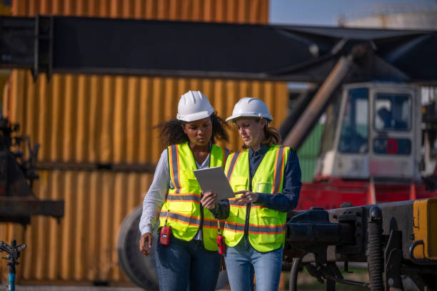 istock Engineer or worker team are standing forklift or truck vehicle are working appear discussing or reviewing document, likely related inspect container factory and industry transportation import export. 2186571699