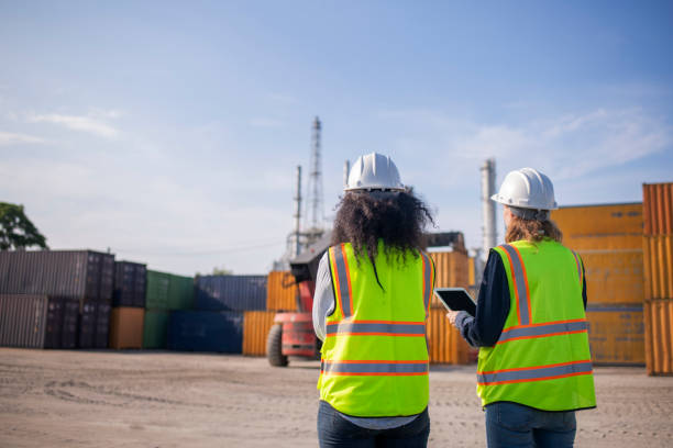 istock Engineer or worker team are standing forklift or truck vehicle are working appear discussing or reviewing document, likely related inspect container factory and industry transportation import export. 2186571735