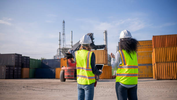istock Engineer or worker team are standing forklift or truck vehicle are working appear discussing or reviewing document, likely related inspect container factory and industry transportation import export. 2186571737