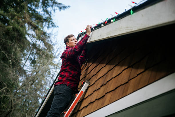 istock Man Putting Up Christmas Lights on Home Exterior 2186571991