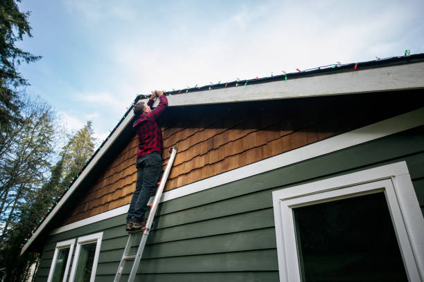 istock Man Putting Up Christmas Lights on Home Exterior 2186572015