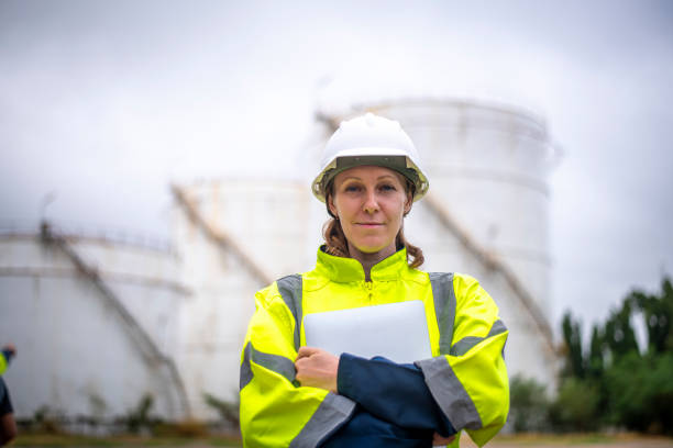 istock Engineers wearing safety gear, including hard hats examining survey a large blueprint tablet standing industrial facility gas or oil refinery engaged in a job requires high safety standards concept 2186572022