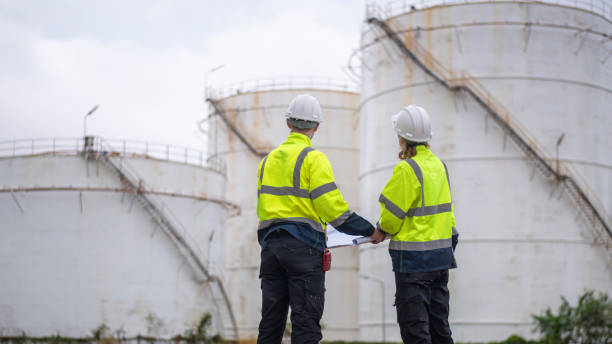 istock Engineers wearing safety gear, including hard hats examining survey a large blueprint tablet standing industrial facility gas or oil refinery engaged in a job requires high safety standards concept 2186572038