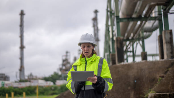 istock Engineers wearing safety gear, including hard hats examining survey a large blueprint tablet standing industrial facility gas or oil refinery engaged in a job requires high safety standards concept 2186572081