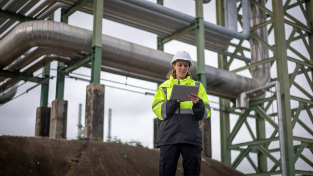 istock Engineers wearing safety gear, including hard hats examining survey a large blueprint tablet standing industrial facility gas or oil refinery engaged in a job requires high safety standards concept 2186572088