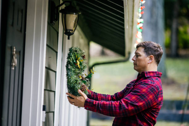 istock Man Decorating Home With Christmas Wreaths 2186572095