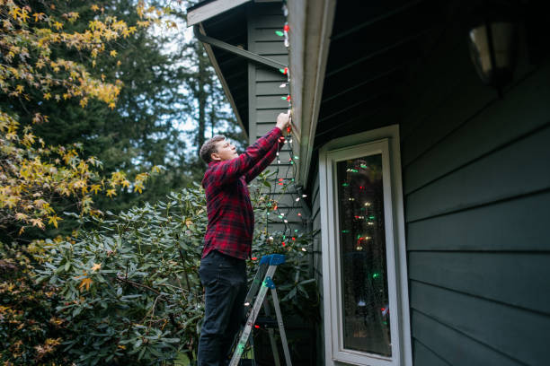istock Man Putting Up Christmas Lights on Home Exterior 2186572177