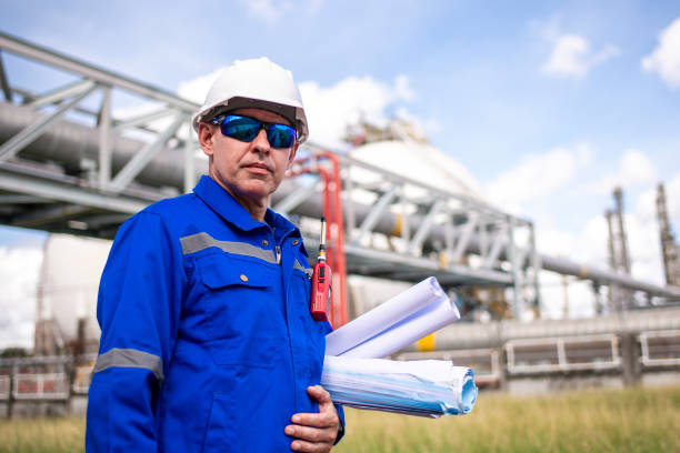istock Engineers wearing safety gear, including hard hats examining survey a large blueprint tablet standing industrial facility gas or oil refinery engaged in a job requires high safety standards concept 2186572430