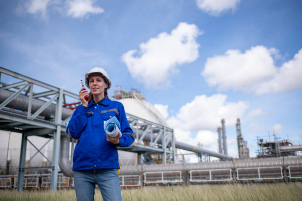 istock Engineers wearing safety gear, including hard hats examining survey a large blueprint tablet standing industrial facility gas or oil refinery engaged in a job requires high safety standards concept 2186572437