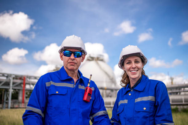 istock Engineers wearing safety gear, including hard hats examining survey a large blueprint tablet standing industrial facility gas or oil refinery engaged in a job requires high safety standards concept 2186572454