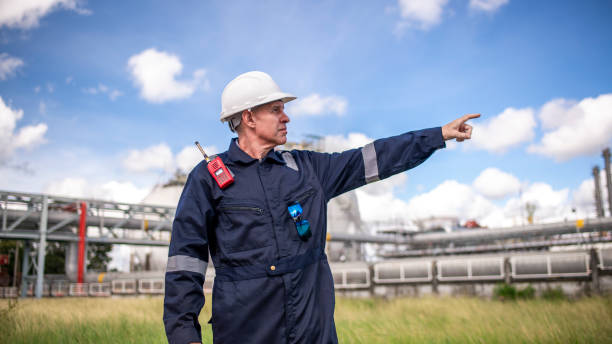 istock Engineers wearing safety gear, including hard hats examining survey a large blueprint tablet standing industrial facility gas or oil refinery engaged in a job requires high safety standards concept 2186572462